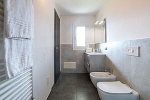Een douche, een haardroger, een bidet, handdoeken