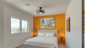 A modern bedroom with a large bed, a city view window, and a unique wall art piece. - The Carter Buyout - 2 Units by AvantStay | Group Stays (Nashville)
