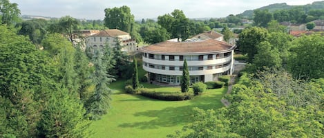 Ein großes, rundes Gebäude mit einem zentralen Innenhof, der von Bäumen umgeben ist.