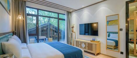 A modern hotel room with a large bed, a TV, a wooden cabinet, and a large window offering a view of the outdoors.