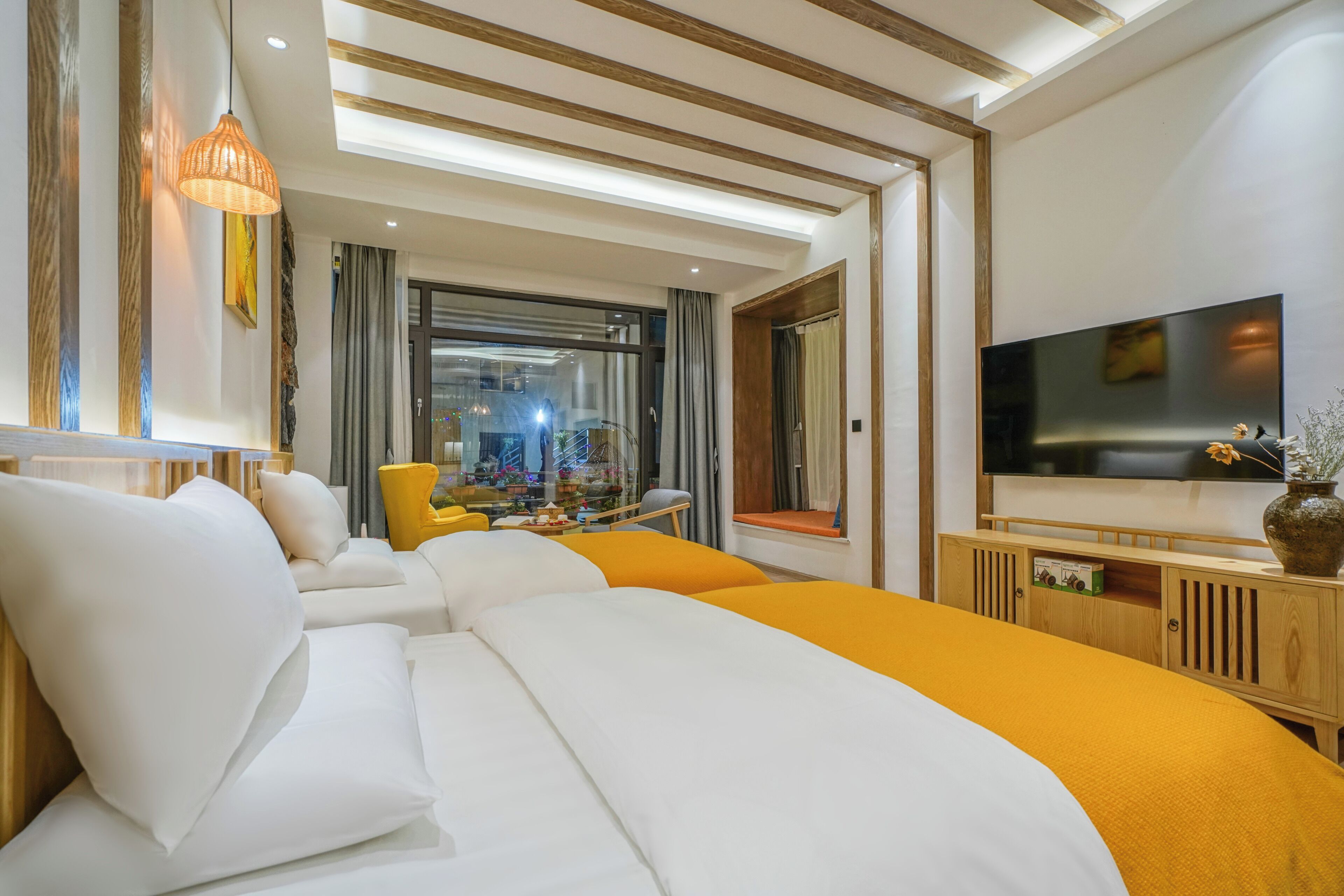 Una camera d'albergo moderna con un letto grande, una televisione e vista sulla città dalla finestra.
