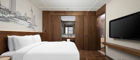Une chambre dâhĂŽtel moderne dotĂ©e dâun grand lit, dâun tĂ©lĂ©viseur Ă Ă©cran plat, dâune tĂȘte de lit en bois et dâune fresque reprĂ©sentant un paysage urbain sur le mur.