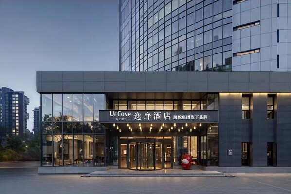 A modern hotel entrance with glass doors, a prominent sign, and a large sculpture outside. - UC by Hyatt  West Railway St Hotel (Tianjin)