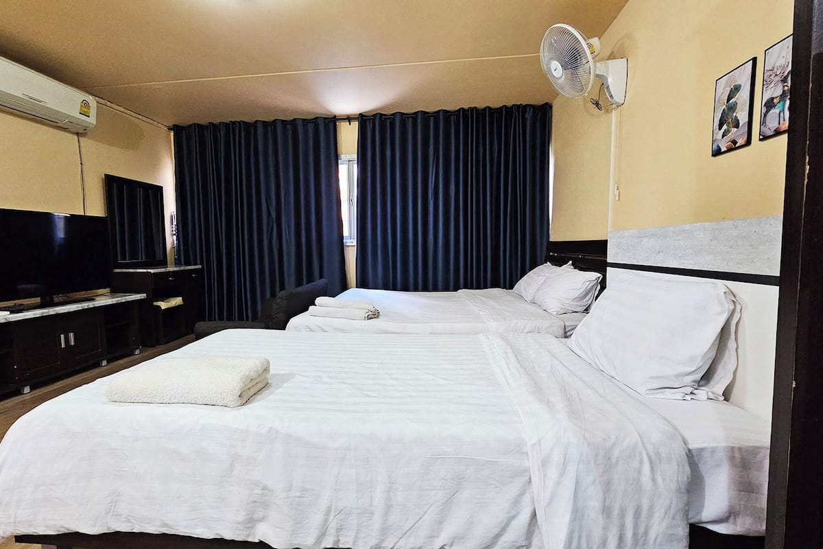 A hotel room with a bed, a TV, a desk, and a chair.