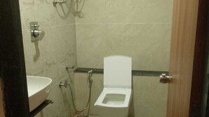 Un baño pequeño con inodoro, lavamanos y ducha.