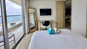 Ein modernes Hotelzimmer mit einem großen Bett, einem Fernseher und einem Balkon mit Blick auf die Stadt.