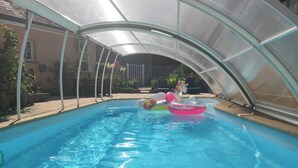 A swimming pool with a transparent roof, surrounded by a covered patio area. - Chic, cozy 35m² tepee with swimming pool in Pontacq near Lourdes. (Pontacq)