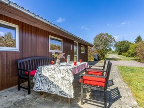 Un bâtiment en bois avec une table et des chaises à l’extérieur.