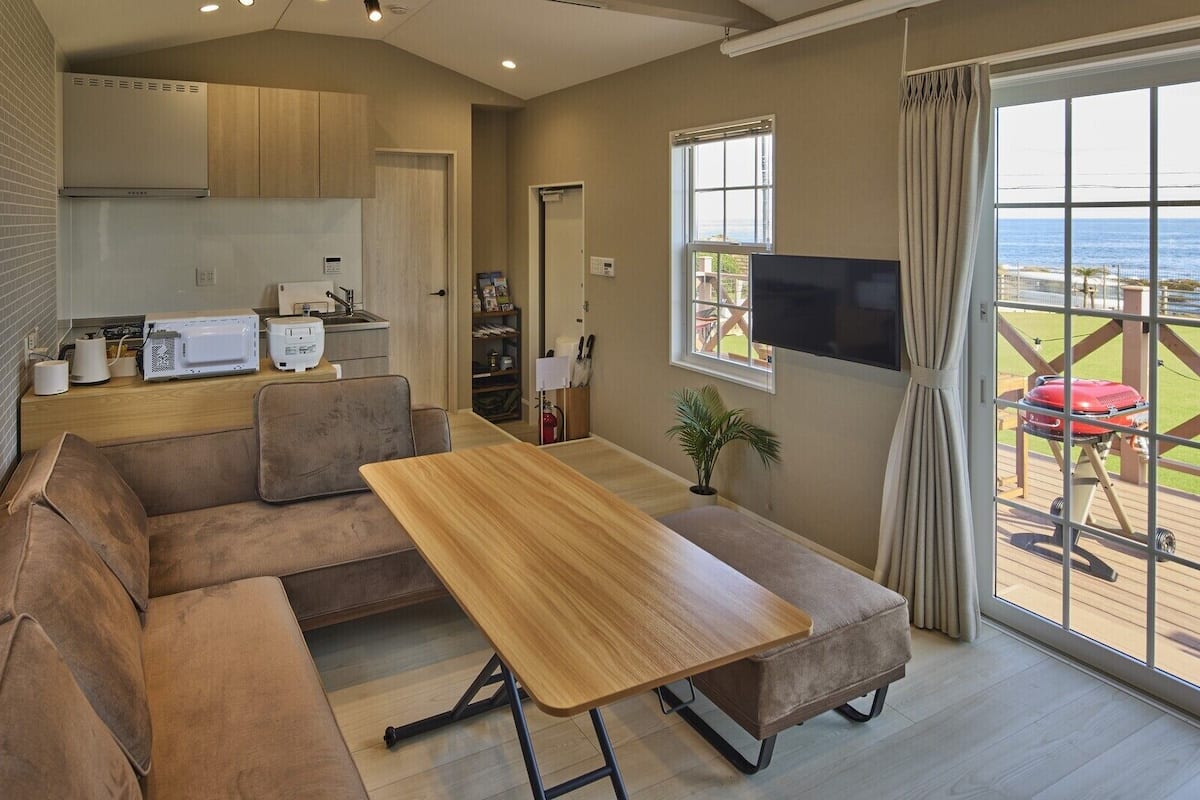 A modern living room with a wooden table, a sofa, and a television.