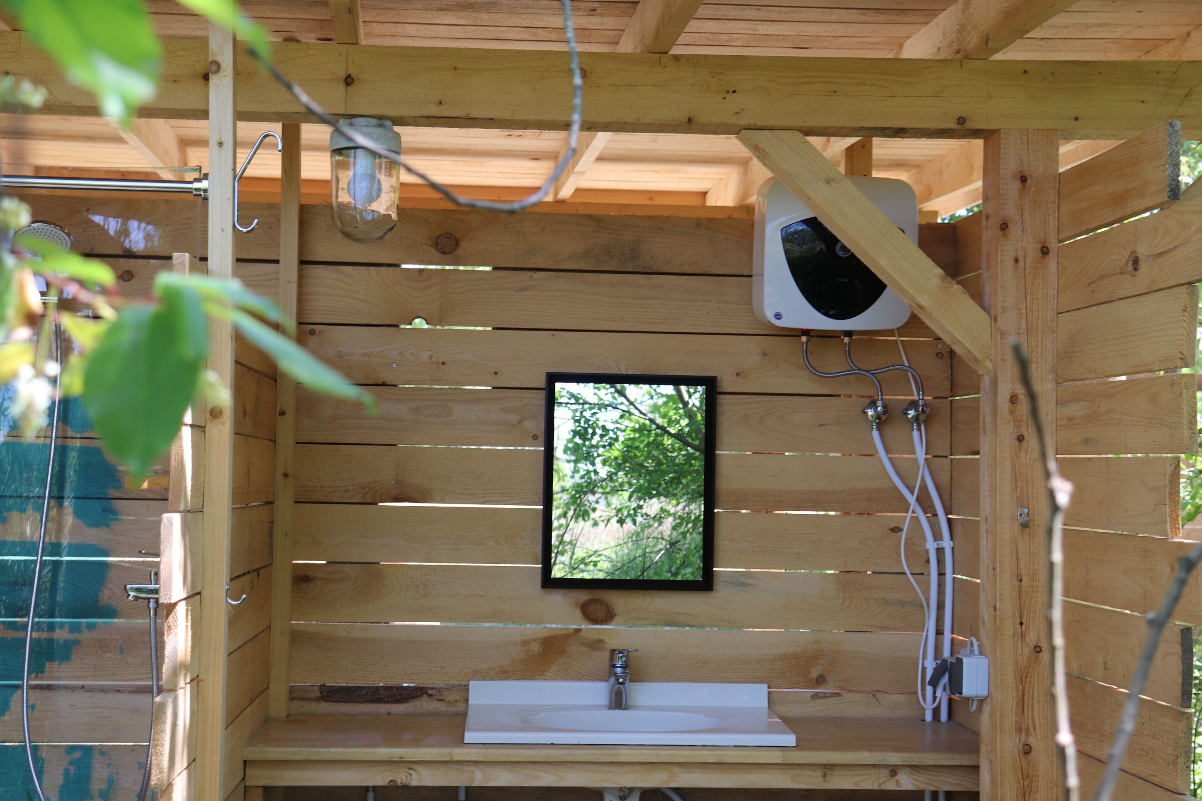 A wooden cabin with a built-in sink and a mirror.