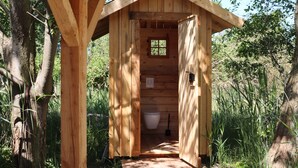 A wooden outhouse with a simple design, a window, and a toilet. - Halbinsel Peenemünde (Peenemünde)