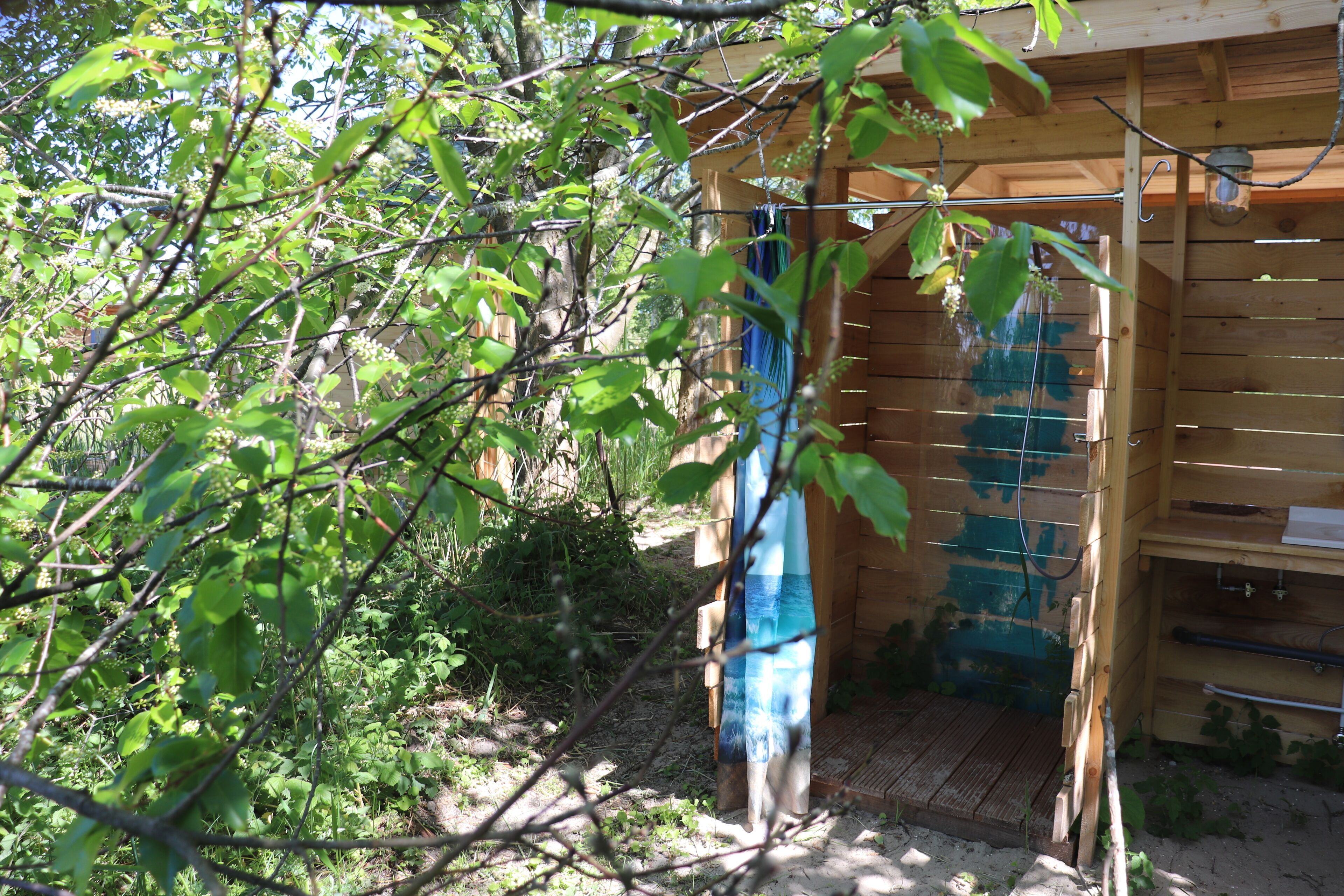Uma cabana de madeira com porta de madeira e um pequeno alpendre.