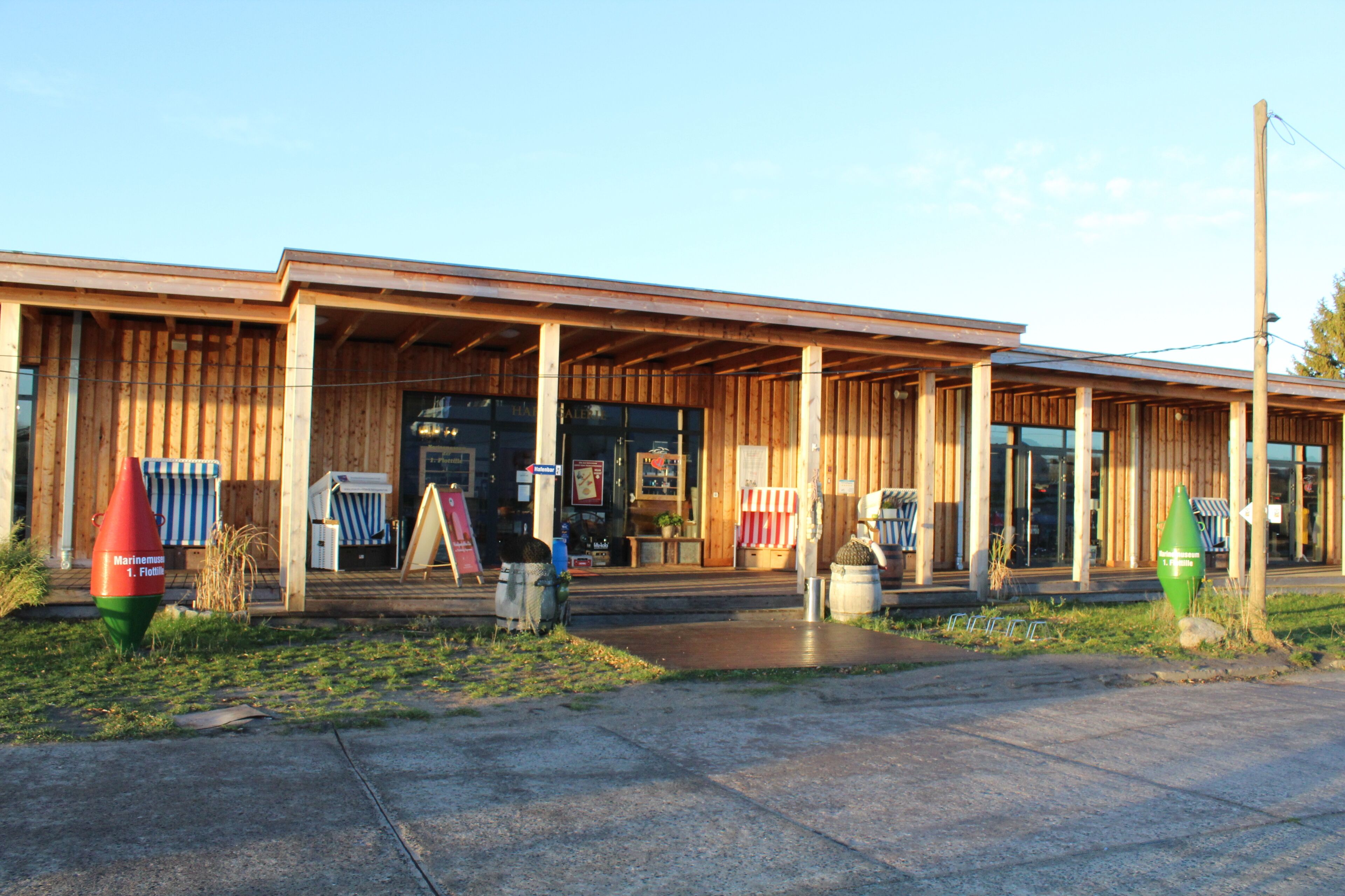 A wooden building with a covered entrance and outdoor seating area.