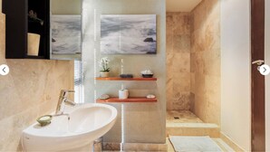 Une salle de bain moderne avec un grand lavabo, un miroir et un espace douche.