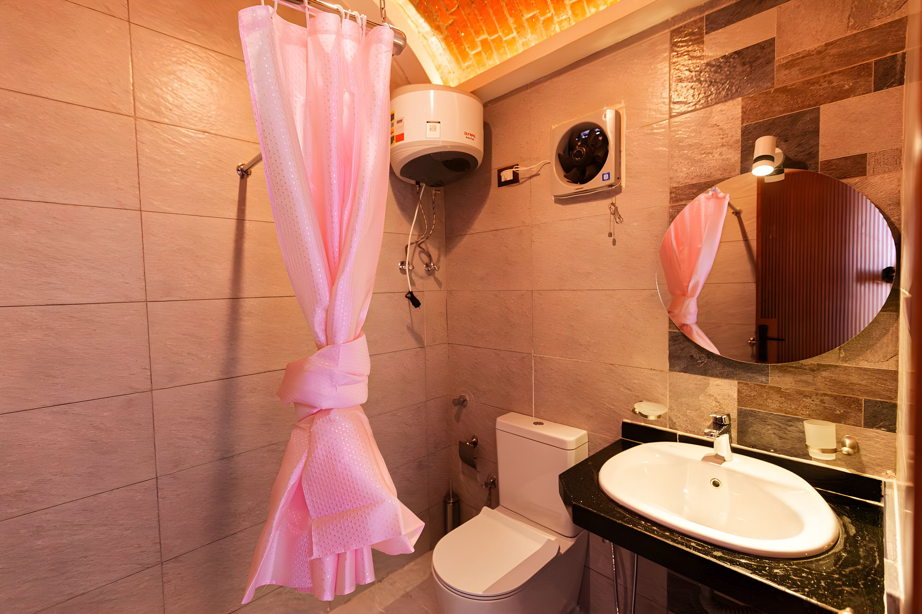 Een badkamer met toilet, wastafel, douchegordijn en handdoekhouder.