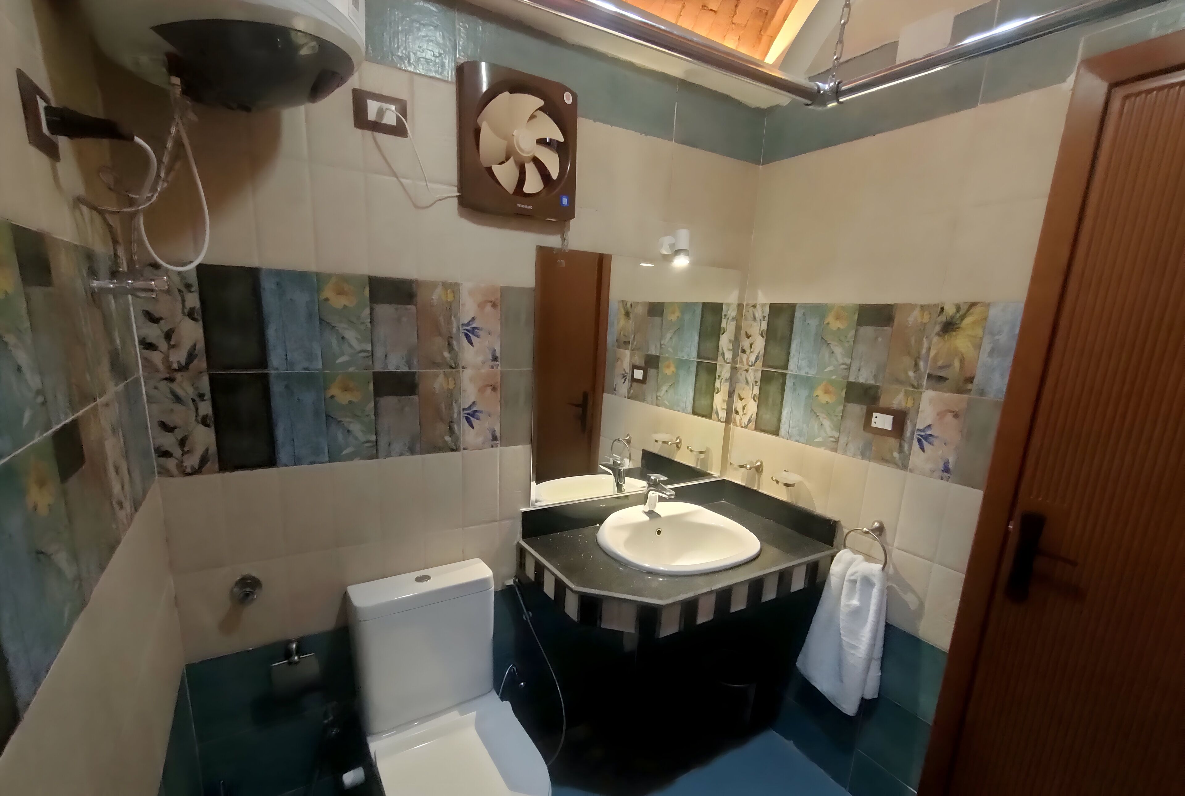 A bathroom with a toilet, sink, and shower.