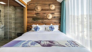 Ein Schlafzimmer mit hölzernem Kopfteil, einem Bett mit weißer Bettwäsche und dekorativen Kissen.