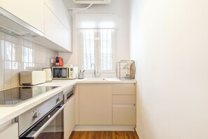 A compact kitchen with white cabinets, a microwave, a toaster, and a sink. - Superb flat in historic centre of Athens (Athens)