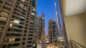 Un edificio de gran altura con varios pisos y balcones, rodeado de otros edificios altos.