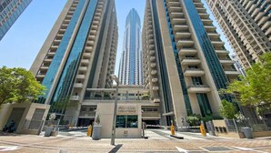 Un edificio de gran altura con un diseño arquitectónico moderno, que cuenta con varios pisos y una entrada central.