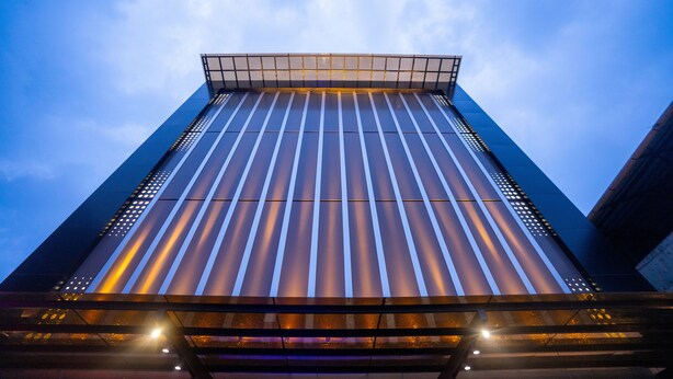 Un edificio moderno e alto, con facciata in vetro e tetto piano.