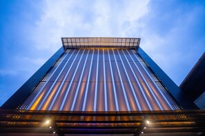 A tall, modern building with a glass facade and a flat roof. - Blue Moon (Ambalapuzha)