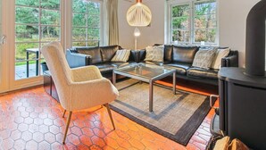 Ein modernes Wohnzimmer mit einer Ledersofa, einem Glastisch und einem Kamin.