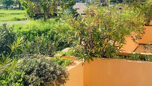 Een balkon met uitzicht op een heuvelstad, met terrasvormige huizen en groen.