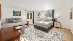 Une chambre moderne avec un grand lit, un bureau et un canapé.