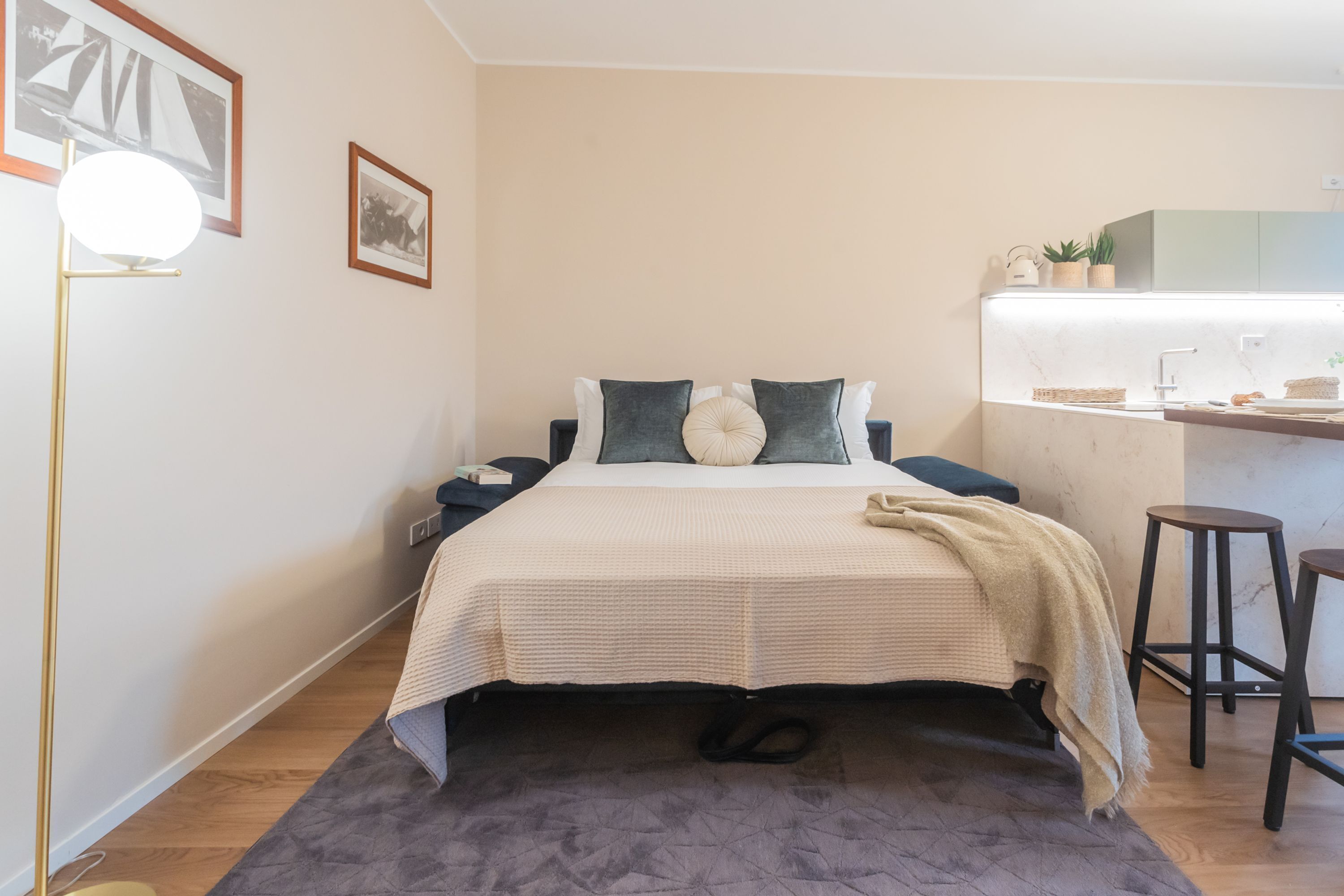 Un dormitorio ordenado con cama, mesitas de noche, un escritorio y una silla.