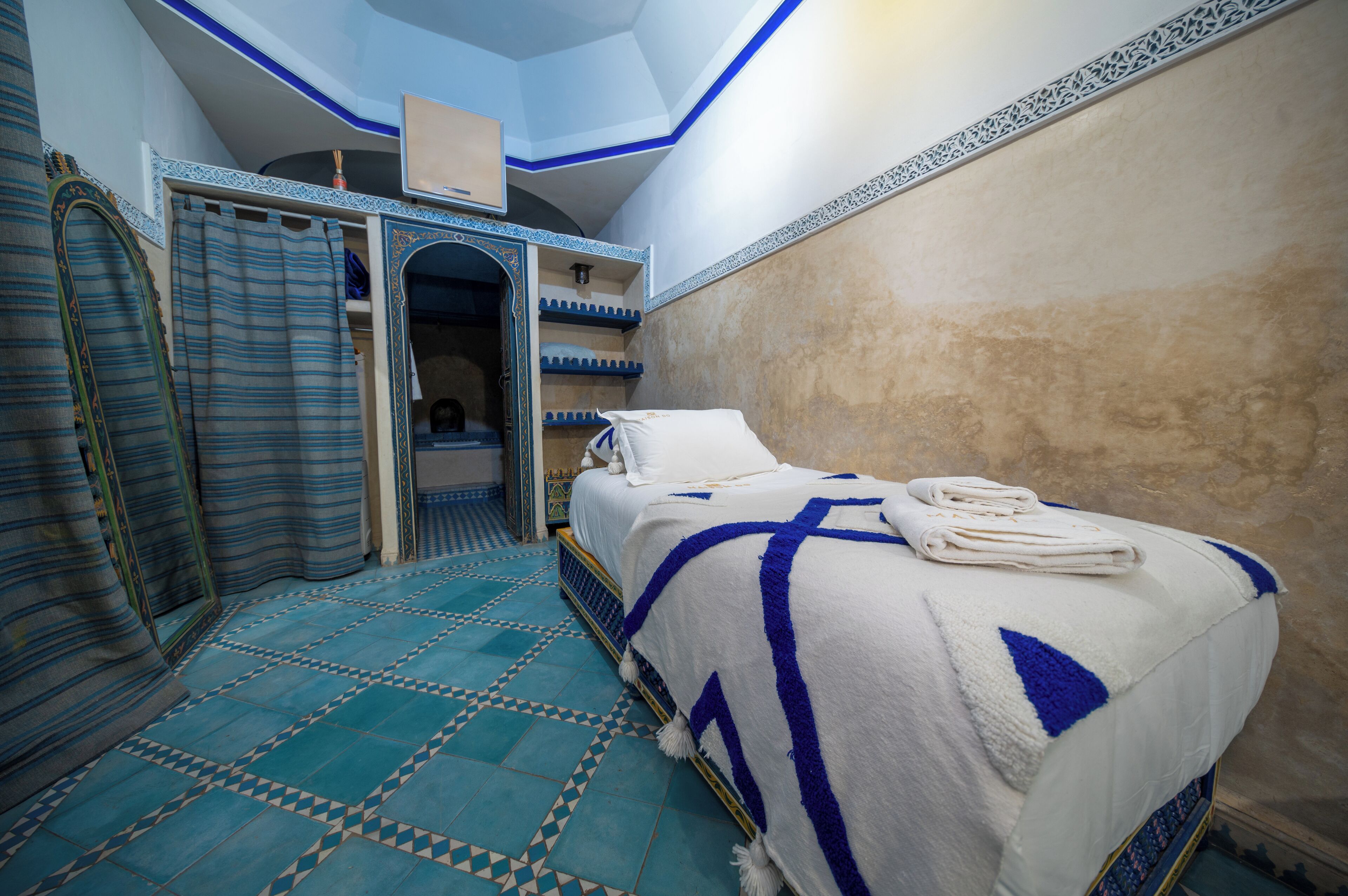 A bedroom with a bed, a wardrobe, and a bathroom.