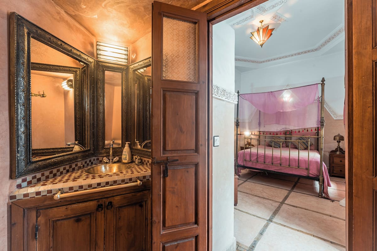 Une salle de bain avec un meuble-lavabo en bois, un grand miroir et un évier.