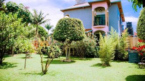 Una casa de dos pisos con un jardín bien cuidado al frente.