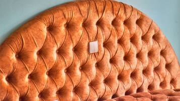A tufted headboard with a button detail and a small white switch.