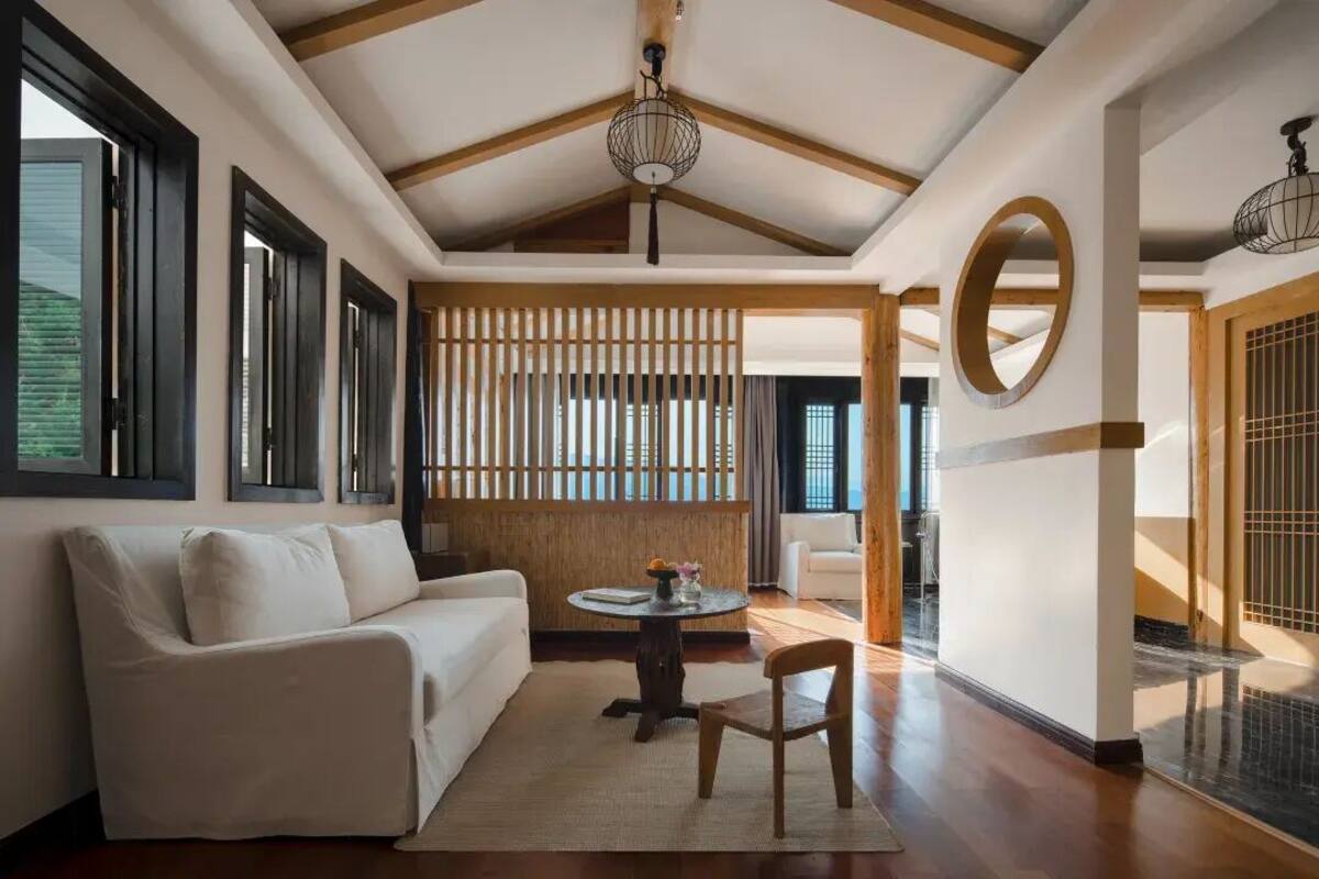 Ein modernes Interieur mit einem weißen Sofa, einem runden Tisch und einer Holzwand.