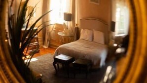 A bedroom with a bed, bedside table, lamp, and a potted plant. - Casa do Cruzeiro (Cascais)