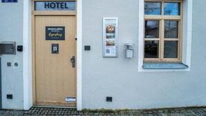 A hotel entrance with a wooden door labeled "HOTEL" and a sign indicating it's the "dreamation. Altstadthotel Regensburg." - dreamcation Altstadthotel Regensburg (Regensburg)