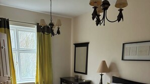 Ένα υπνοδωμάτιο με προσεγμένη διαρρύθμιση, που περιλαμβάνει ένα μεγάλο κρεβάτι, ένα γραφείο και μια καρέκλα.