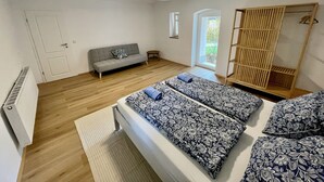 Una camera da letto con un letto, un divano, un armadio e una finestra.
