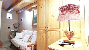 A cozy room with a wooden bed, a wooden cabinet, and a heart-shaped lamp.
