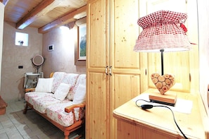 Una habitación acogedora con una cama de madera, un armario de madera y una lámpara con forma de corazón.