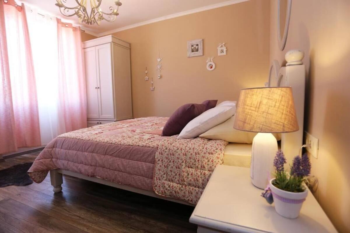 Une chambre à coucher avec un lit, une lampe de chevet et une petite plante en pot.