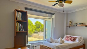 A bedroom with a wooden bed, a desk, and a bookshelf. - Villa Moreno - Ole Solutions (Puerto de Santa María)