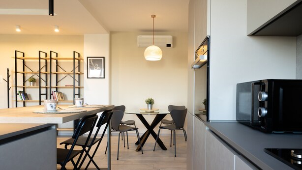 A modern kitchen with a central island, dining area, and built-in appliances. - Cinecitt Dreams in Rome (Rome)