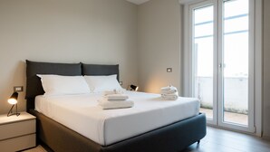 A modern bedroom with a large bed, a nightstand, and a bedside lamp. - Cinecitt Dreams in Rome (Rome)