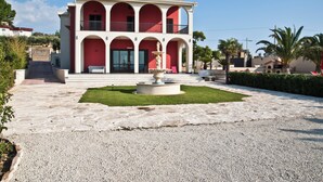 A two-story building with a central courtyard, a fountain, and a red and white color scheme.