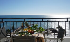 Enjoy breathtaking ocean views from this balcony, complete with a table set for a romantic evening.