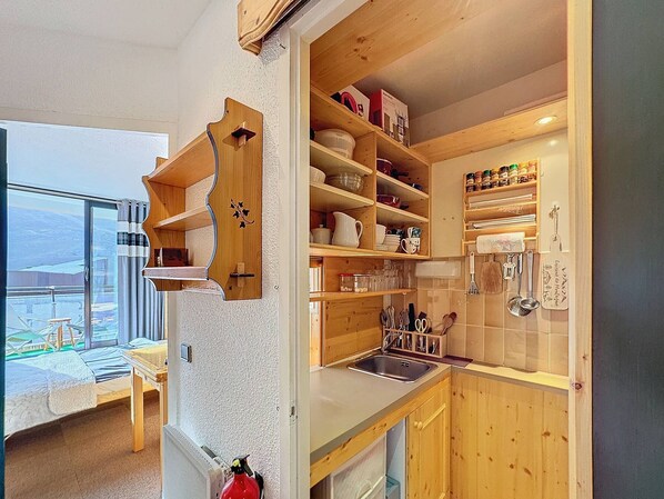 Enjoy cooking in this well-equipped kitchen with sink and open shelving for kitchen essentials.