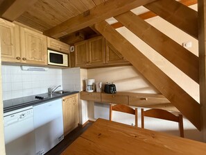 A kitchen with wooden cabinets, a microwave, a coffee maker, and a dishwasher.