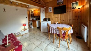 A cozy cabin interior with a dining area, kitchen, and a living space. - Charming duplex for 5 near Blue Lake (Morillon Village)